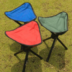 Three portable stools in blue, red, and green on grass