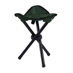 Green folding stool with black legs on a white background